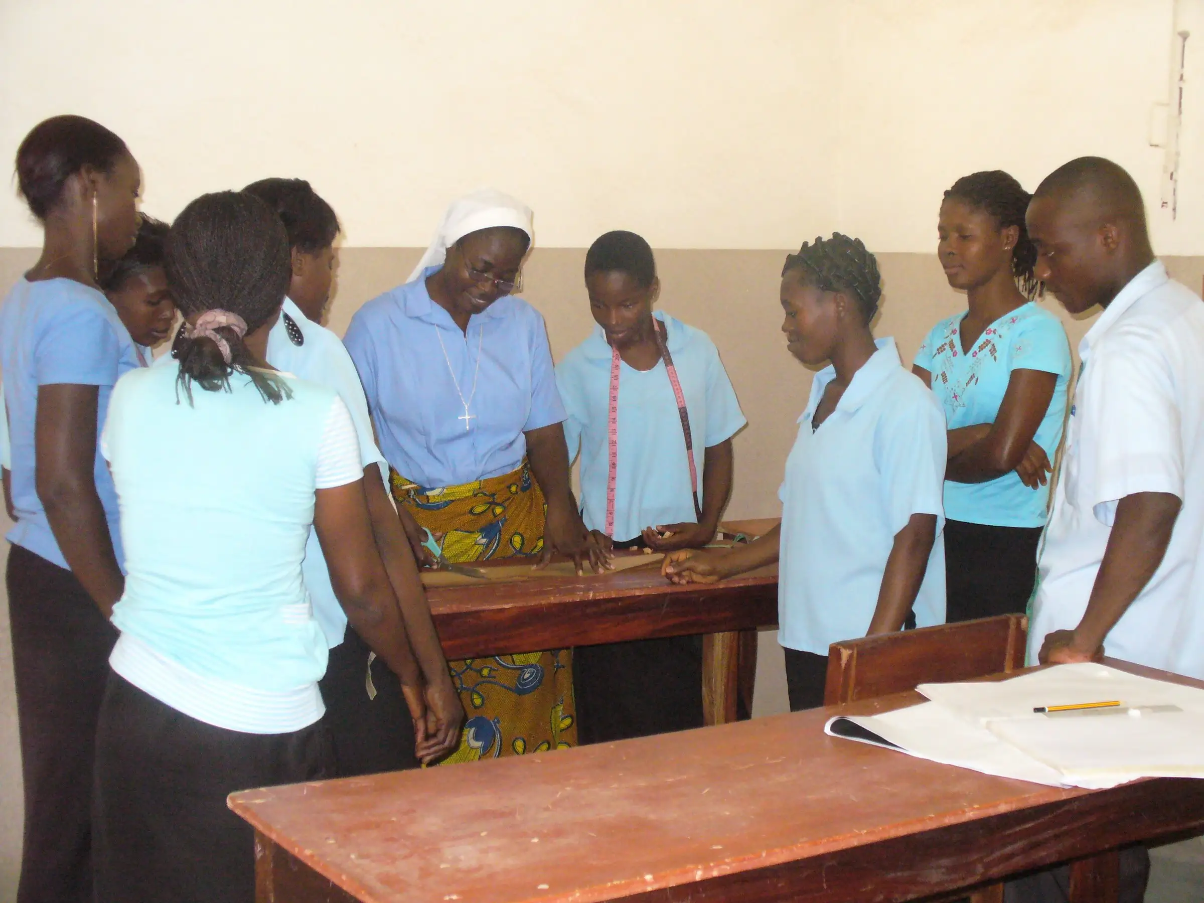Une sœur et des jeunes travaillent ensemble autour d’une table de coupe