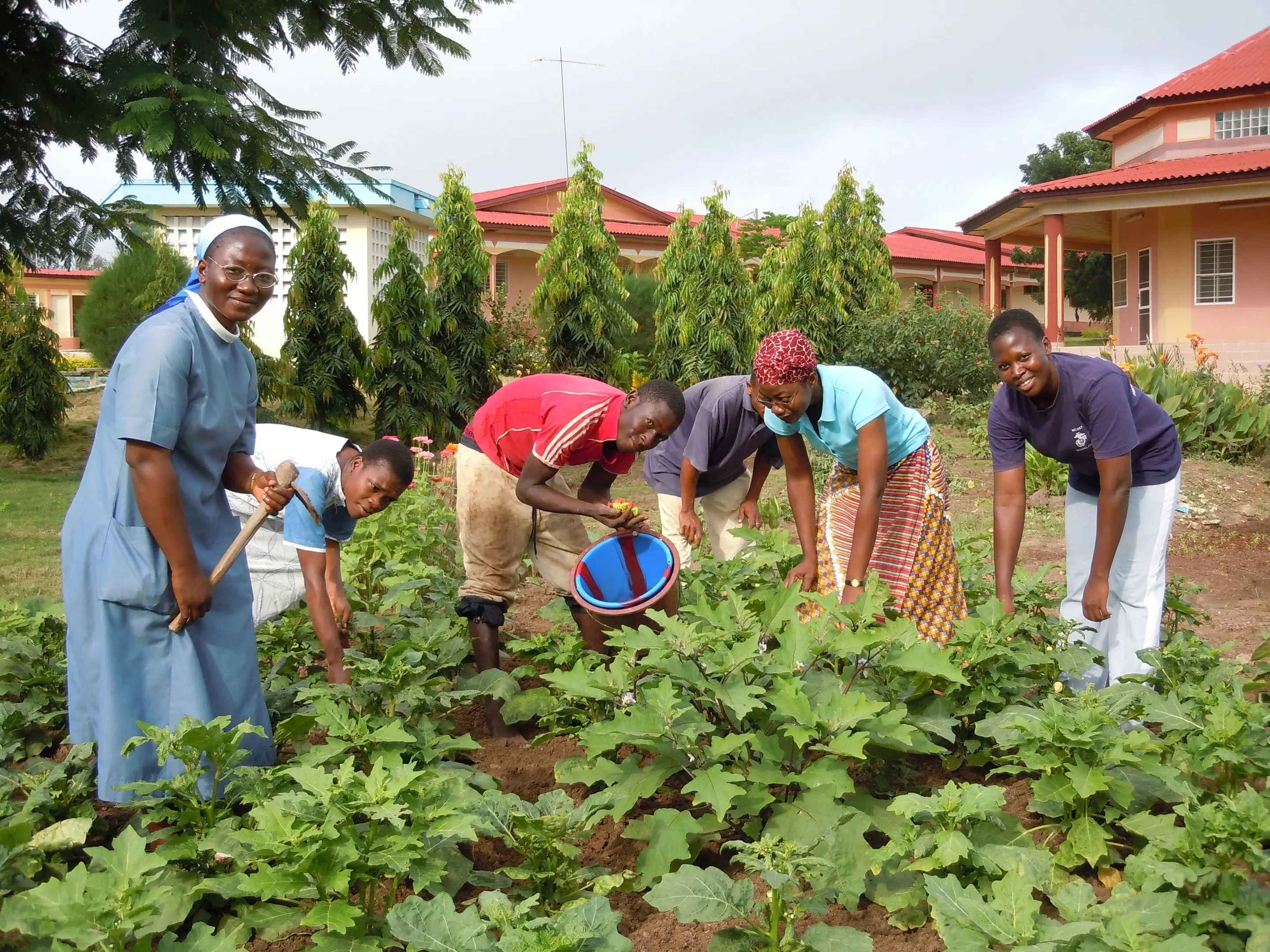 Une sœur et des jeunes femmes au jardin du noviciat de Yamoussoukro